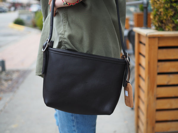Black leather purse measuring 10 inch width,  6 inch tall, 2.25 inch Deep.  Brass rounded buckles.