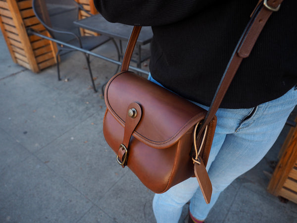 Medium brown leather purse with flap.  Solid brass quick snap and rounded buckle.